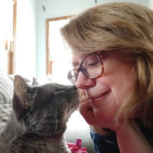 Grey cat and Pet Care Services Specialist, Darlene, touching noses.