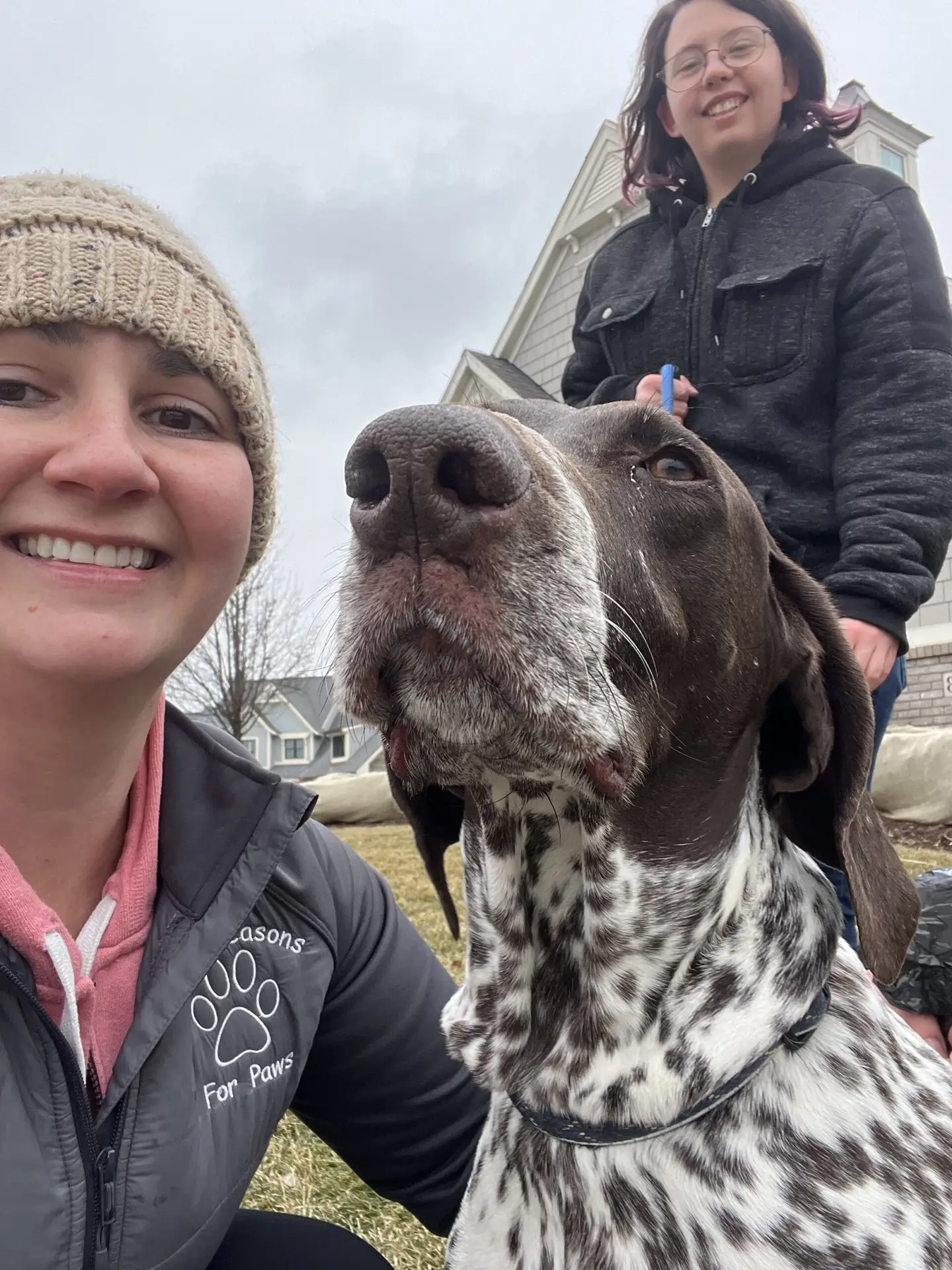 Two pet care specialists guiding a dog through a socialization exercise, emphasizing the importance of continuing to socialize your dog for their overall well-being.