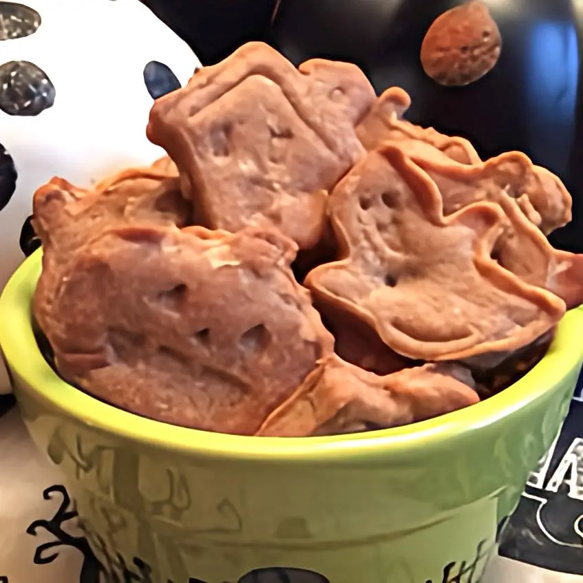 An image of homemade Apple Dog Treats in halloween themed shapes.