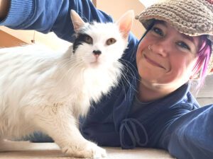 Four Seasons For Paws pet care specialist provides personalized care and cuddles for a cat in their living room.